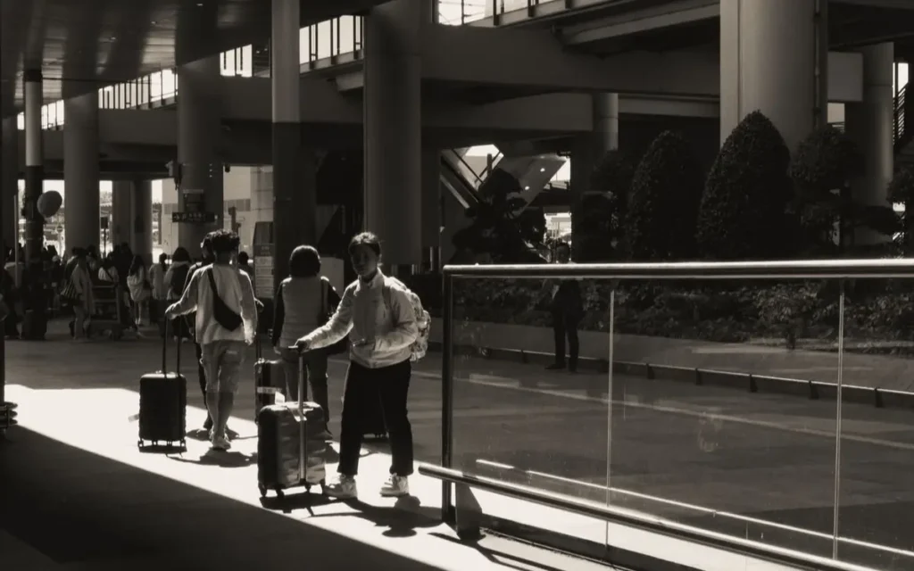 Silhouettes of travelers with luggage at a sunlit modern air
