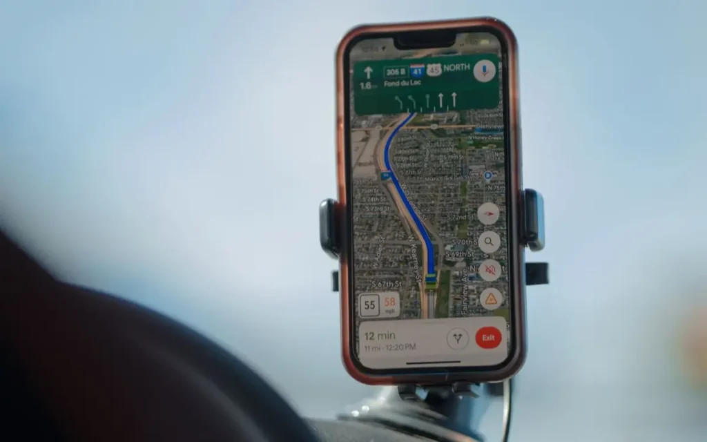 A smartphone with GPS navigation app mounted on a car dashbo